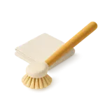 A dish brush next to a folded cloth